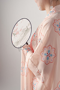 汉服传统文化女孩穿着汉服拿着折扇侧面特写摄影图配图