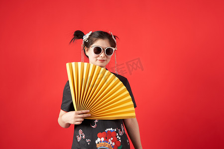 国潮中国风女子穿着汉元素衣服手拿折扇摄影图配图