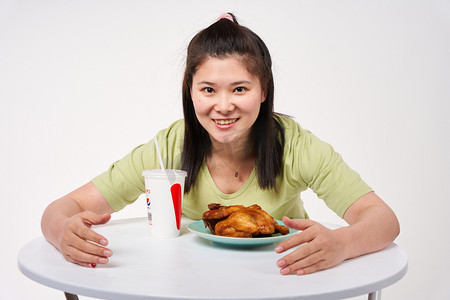 餐饮烧烤摄影照片_减肥餐饮女孩看到烤鸡肥宅水非常开心摄影图配图