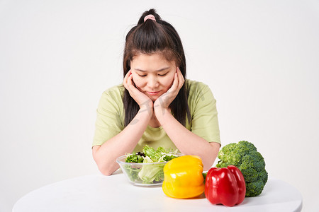 减肥控制饮食女孩看着面前的沙拉十分苦恼摄影图配图