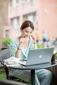 学习白天用电脑学习的女学生户外看电脑笑摄影图配图