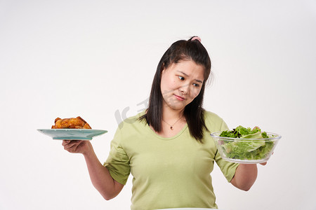 减肥控制饮食女孩十分烦恼放弃高热量改吃沙拉摄影图配图