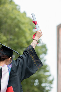 毕业季白天举起毕业证户外举起毕业证摄影图配图