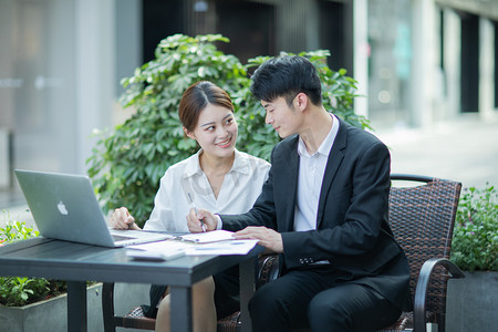 面试对话摄影照片_商务白天商务男女户外沟通对话摄影图配图