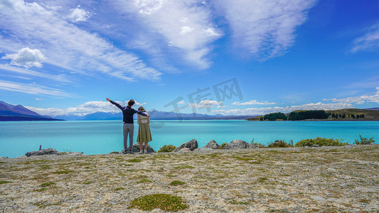 情侣旅行摄影照片_湖边情侣正午夫妻湖边全身背影摄影图配图