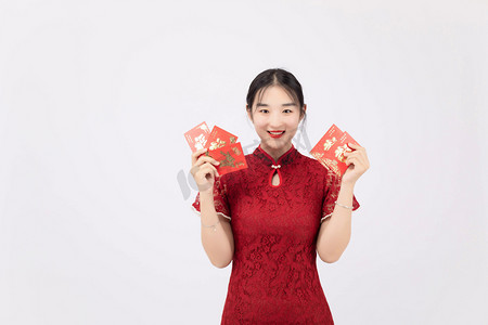 国潮人物春节旗袍女孩室内手拿红包摄影图配图