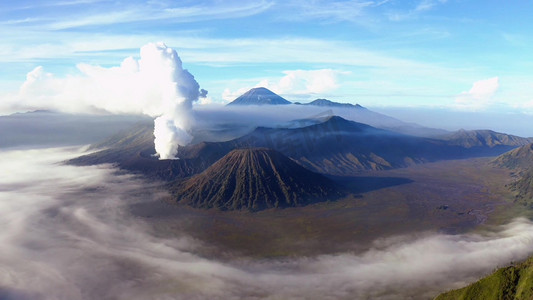 冒烟的茶杯摄影照片_火山活动冒烟高清航拍远景