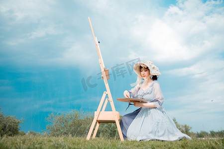 夏天户外摄影照片_文艺清新白天挤颜料的美女户外草坪蹲着调色摄影图配图