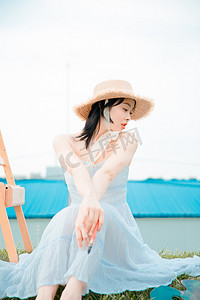 文艺清新白天穿着白裙子的写生美女户外草坪望向一边摄影图配图