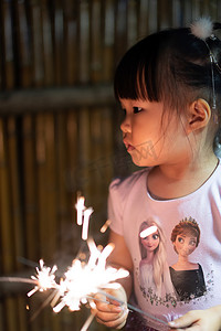 玩烟花的女孩下午儿童夜景玩烟花摄影图配图