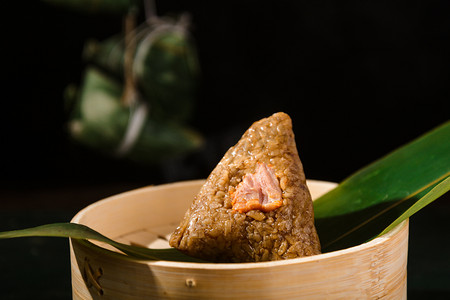端午白天肉粽　粽叶室内笼屉上摄影图配图