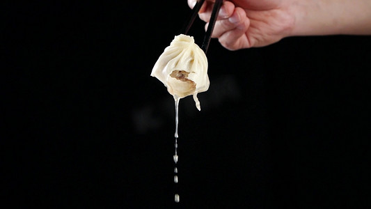 筷子夹起汤包灌汤包漏汤汁上海灌汤包