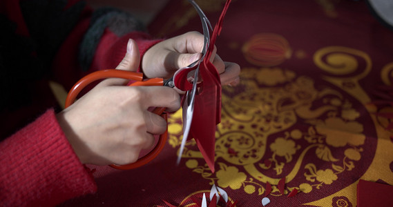 蓝色剪纸风边框摄影照片_实拍中国传统文化新年剪纸手艺