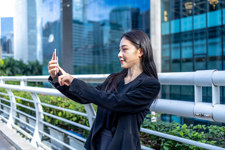 商务人像下午职场女性写字楼拿手机自拍摄影图配图