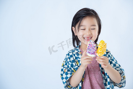 冰棍摄影照片_夏日儿童白天笑着的儿童室内白背景开心的拿着冰棍摄影图配图