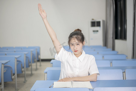 高考夜晚一个学生在教室举手回答摄影图配图