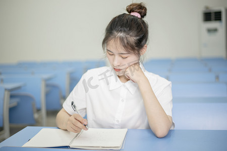 晚上摄影照片_高考晚上一个女学生在教室学习摄影图配图