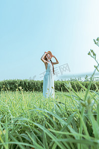 文艺夏天美女白天穿着白色长裙的美女户外田野站着摄影图配图