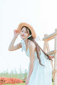 夏天文艺白天穿着白色长裙的美女户外扶帽子摄影图配图