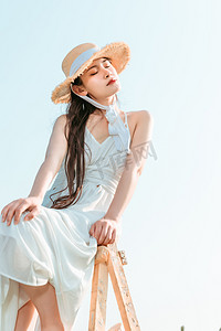 文艺夏天白天穿着裙子戴着帽子的美女户外田野摆拍摄影图配图