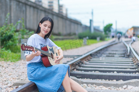 水墨风乐器吉他摄影照片_弹吉他的少女