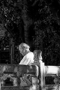 重阳节摄影照片_白发老人独自坐在公园石椅上