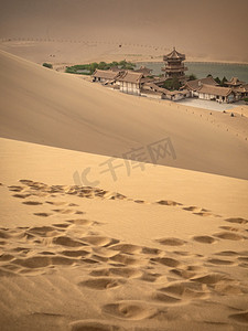 沙漠摄影照片_敦煌风光白天沙漠鸣沙山月牙泉足迹美景摄影图配图