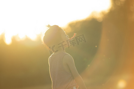 夏日儿童人像夕阳一个孩子麦田叼西瓜皮享受阳光摄影图配图