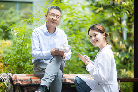 老头摄影照片_老年健康白天老人和女医生户外交流病情摄影图配图