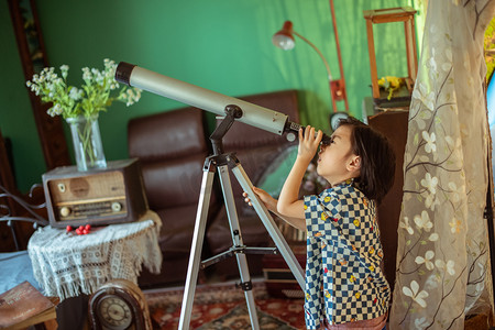 夏日儿童人像白天帅气男孩室内用望远镜观察摄影图配图