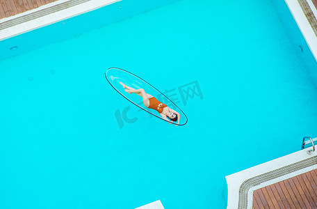 夏日清凉白天比基尼美女泳池躺在水面摄影图配图