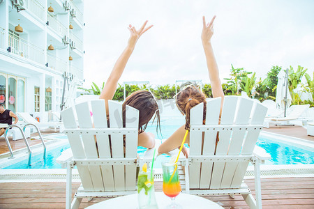 夏天泳池摄影照片_夏天清新美女白天两位比基尼美女户外泳池比耶的手势摄影图配图