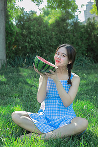 夏季休闲白天美女公园草坪吃瓜纳凉摄影图配图