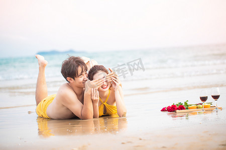 爱情白天一对情侣沙滩蒙眼睛摄影图配图