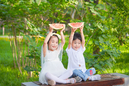 夏季大暑摄影照片_夏季白天女孩男孩公园西瓜摄影图配图