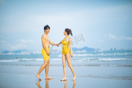 爱情白天一对年轻情侣沙滩手拉手摄影图配图