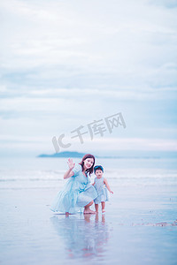 亲子时光白天母女俩户外沙滩依偎在一起摄影图配图