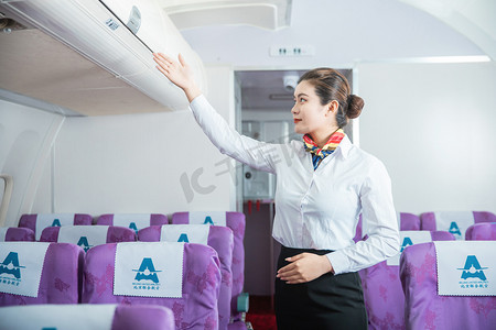 空乘白天空姐客舱内展示行李架摄影图配图