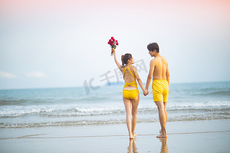 爱情夏天白天一对情侣沙滩手拉手摄影图配图