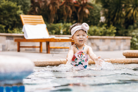 儿童夏天白天穿泳衣的女童户外泳池边玩水摄影图配图