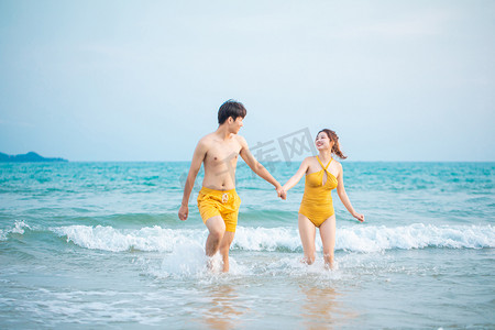 爱情白天一对情侣户外沙滩手拉手摄影图配图