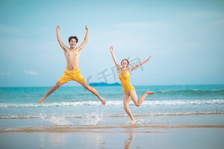 情人节爱情白天一对情侣沙滩跳起来摄影图配图