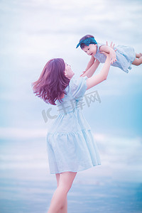 亲子关系白天母女俩户外沙滩举高高摄影图配图