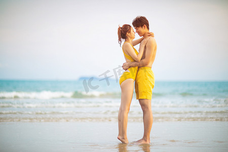 海边情侣摄影照片_爱情情人节白天一对情侣沙滩面对面拥抱摄影图配图