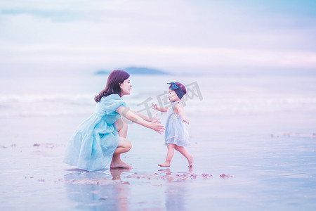 粉色沙滩摄影照片_亲子关系白天穿着亲子装的母女俩沙滩拥抱摄影图配图