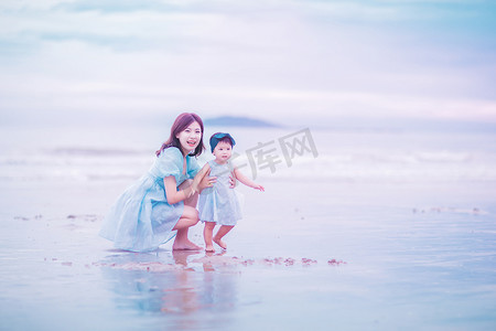 粉色沙滩摄影照片_亲子关系傍晚母女俩沙滩玩耍摄影图配图