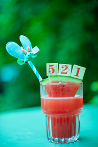 夏日饮品白天新鲜西瓜汁绿色桌子上文艺唯美背景摄影图配图