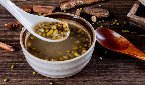 复古风夏天美食白昼一碗绿豆汤室内餐桌用勺子喝绿豆汤摄影图配图