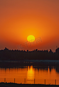 黄色天空摄影照片_夏天自然风光傍晚日落户外湖泊边夕阳西下摄影图配图