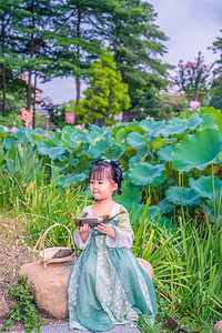 汉服荷花池下午女童荷花池坐吃粽子摄影图配图